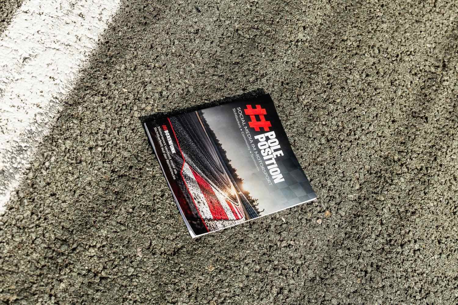 Das Cover des #PolePosition-Ratgebers auf dem Asphalt der Rennstrecke